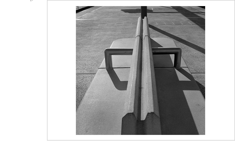 Light and showdow accent the strong lines of a B.A.R.T. platform and bench in Oakland, California.