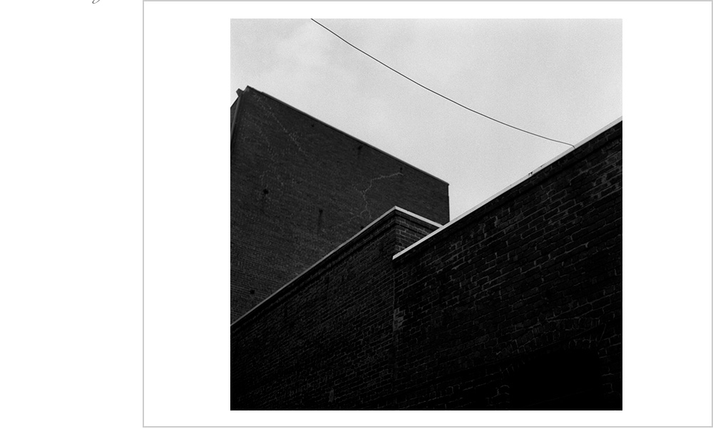 Power lines, contrast and a magnificent brick wall turn ordinary into stunning architecture.