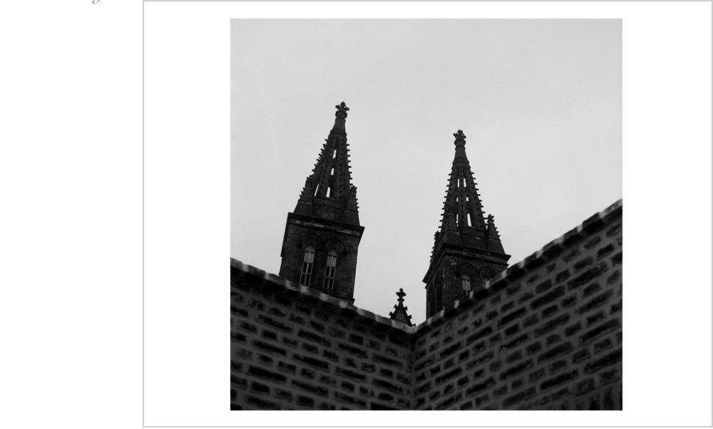 A foreboding brick wall and dramatic angles frame Prague's historic fort, Vyšehrad.