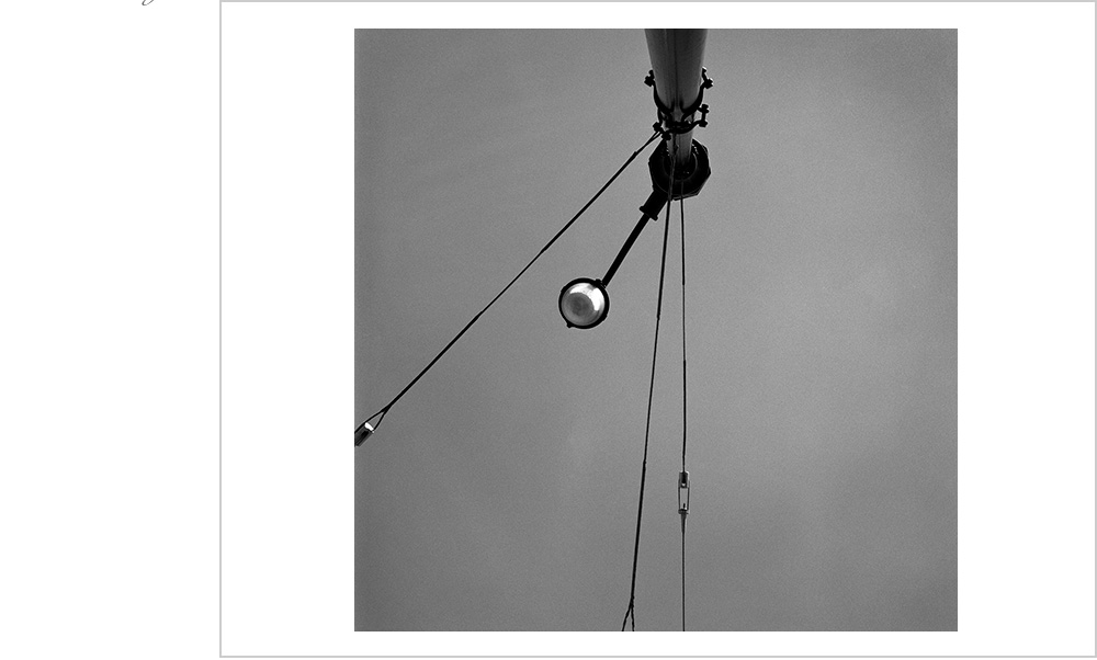 Looking up into the San Francisco sky and discovering a street lamp held firm by wires.