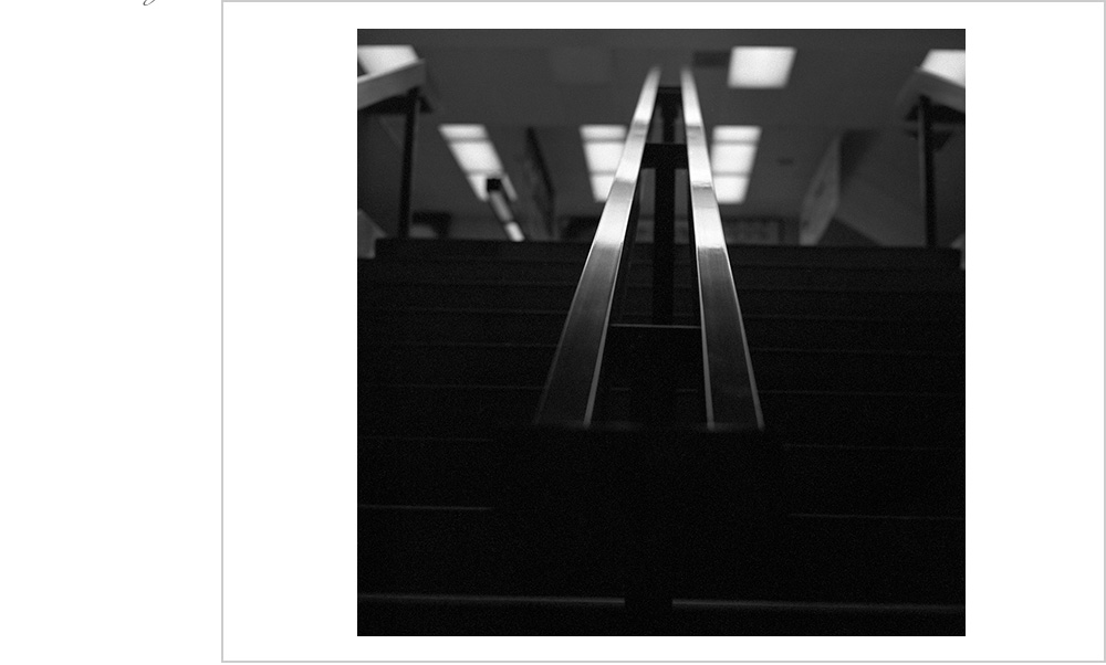 The high shine of chrome handrail upstairs to the B.A.R.T. station in Oakland, California.