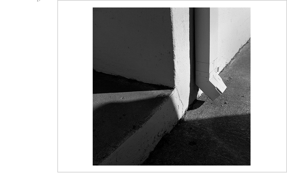 A dramatically lit downspout in industrial Oakland, California.