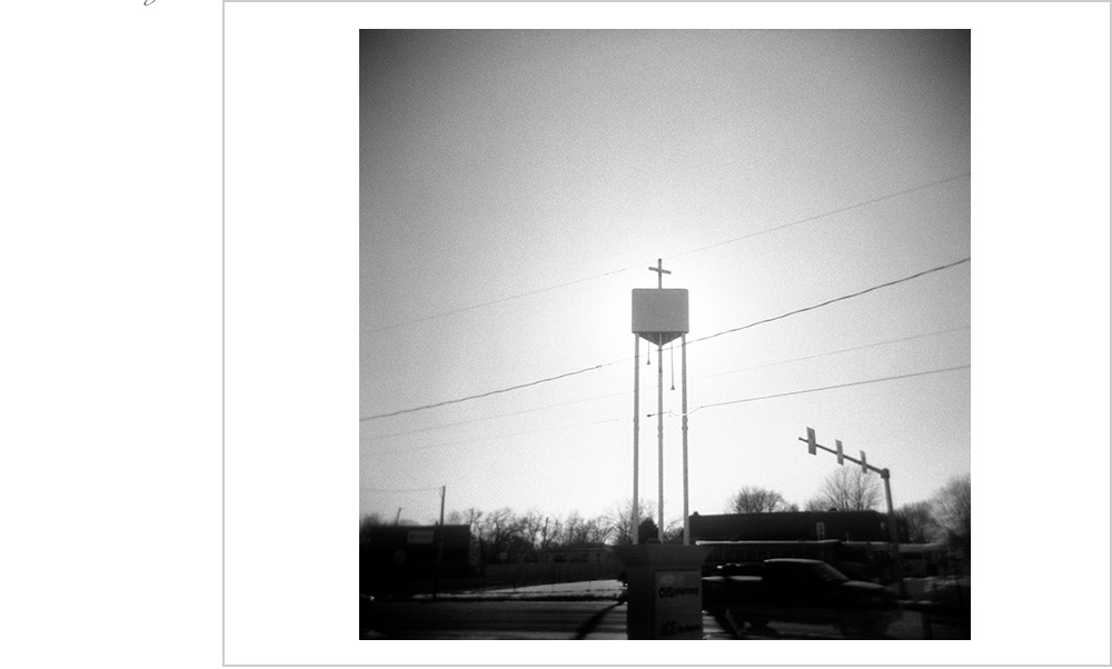 Silhouetted by a setting sun and flanked by power lines, the shine of the word is only for those not too busy in traffic.
