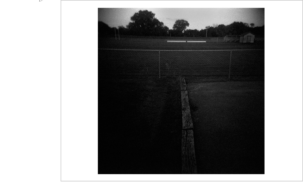 Sometimes it's the simple things that carry the greatest impact. Like the stark white of these beches amidst the suffocating black of the rest of the scene. Pee wee footbaal field and a Holga in Des Moines Iowa