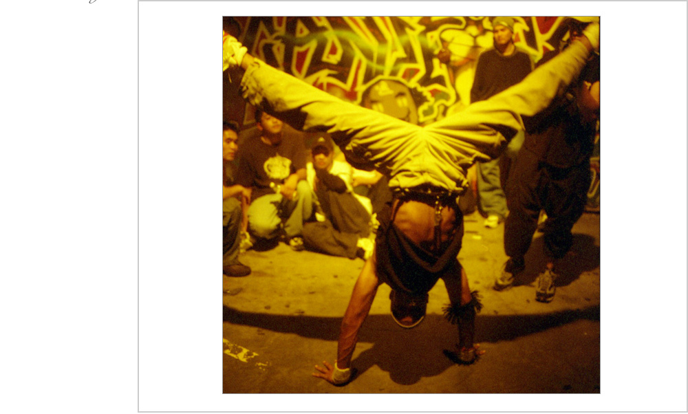 A break dancer shows off his moves in front of his crew at this underground rave in Oakland, California, 1999.